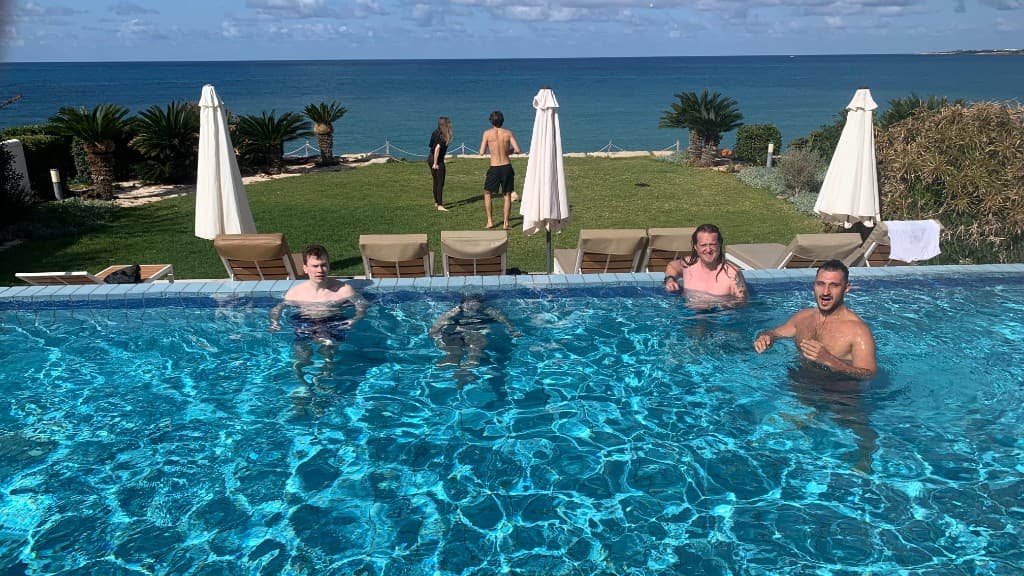 Community relaxing at the villa pool overlooking the sea